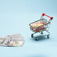 Photograph of hundred dollar bills and a shopping cart full of prescription drugs