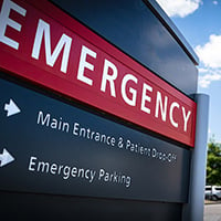 Hospital Emergency Sign with hospital building in the background